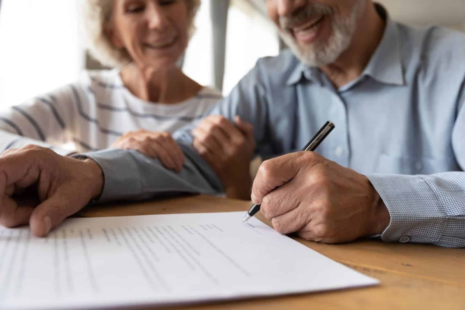 two elderly people signing a contract - estate litigation
